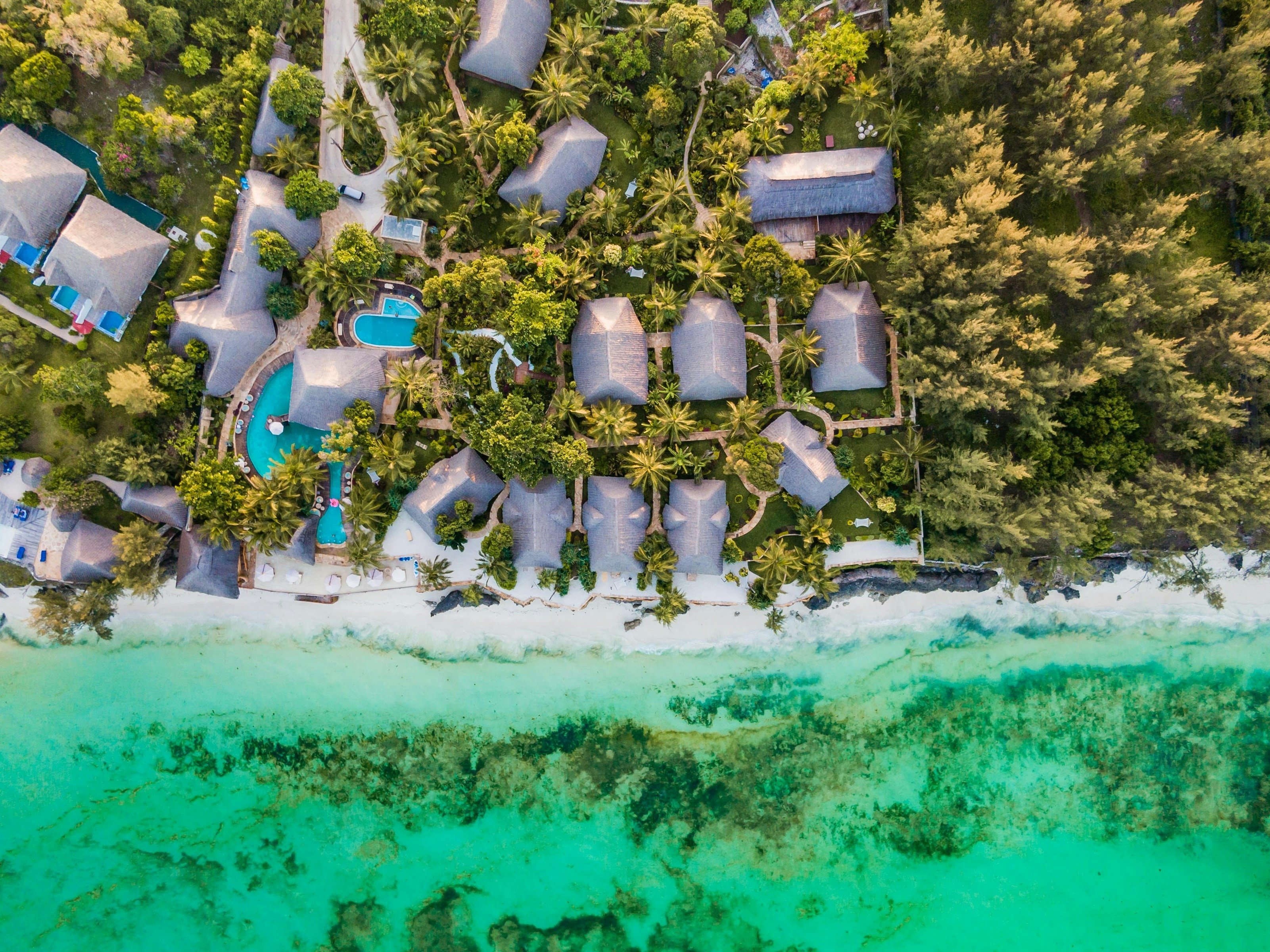 vy ovanifrån på ett resort vid strand och djungel på zanzibar