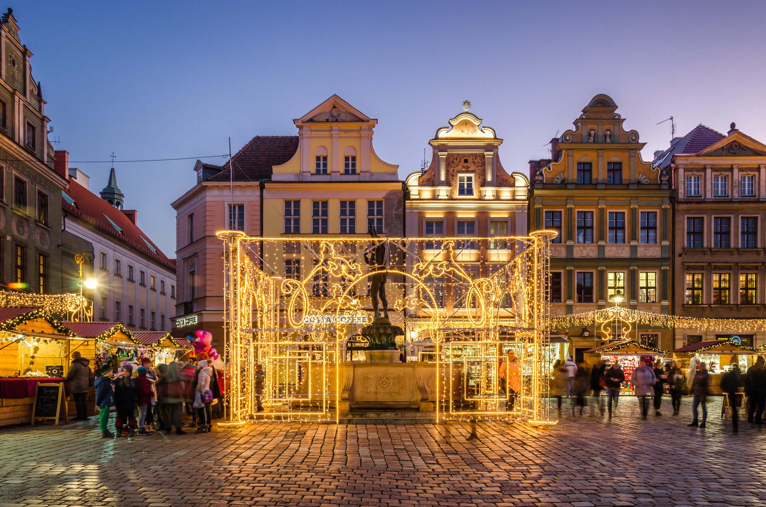 Julmarknad i Poznańs gamla stad med ljusdekorationer, historiska byggnader och marknadsstånd – julresa till Polen
