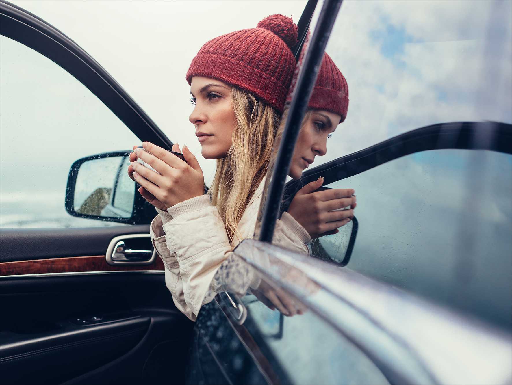 Kvinna tittar ut genom fönstret på bil vintertid