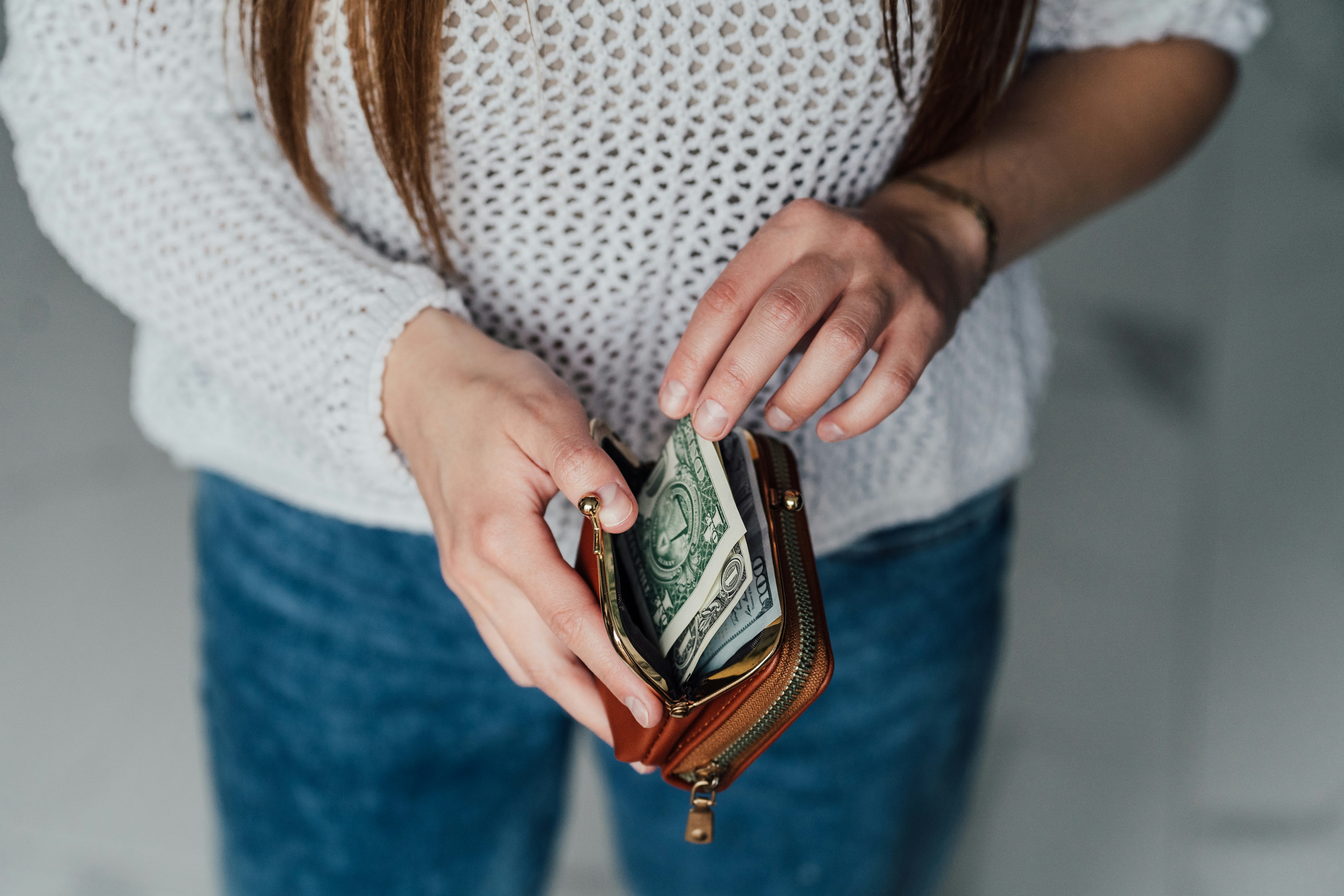 Woman holding a wallet and counting her cash
