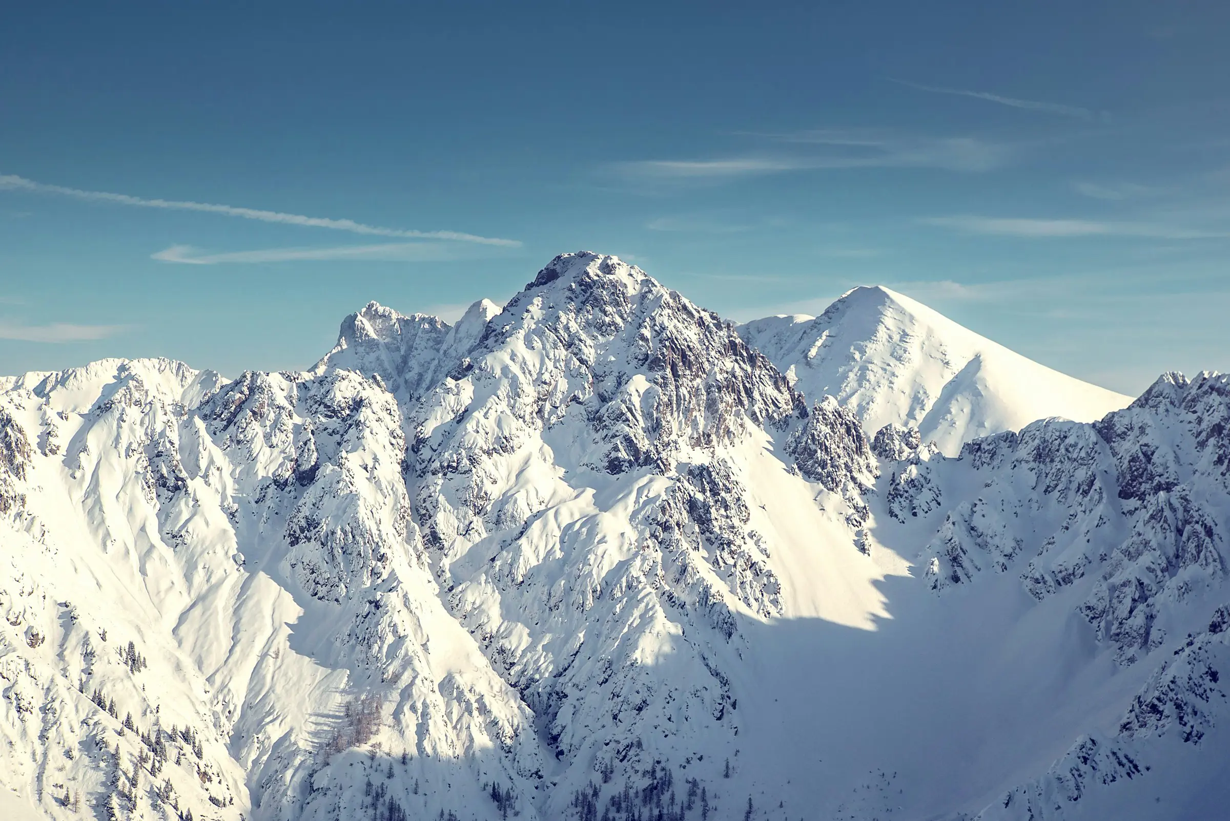 Snow-covered mountain peaks under a clear blue sky.