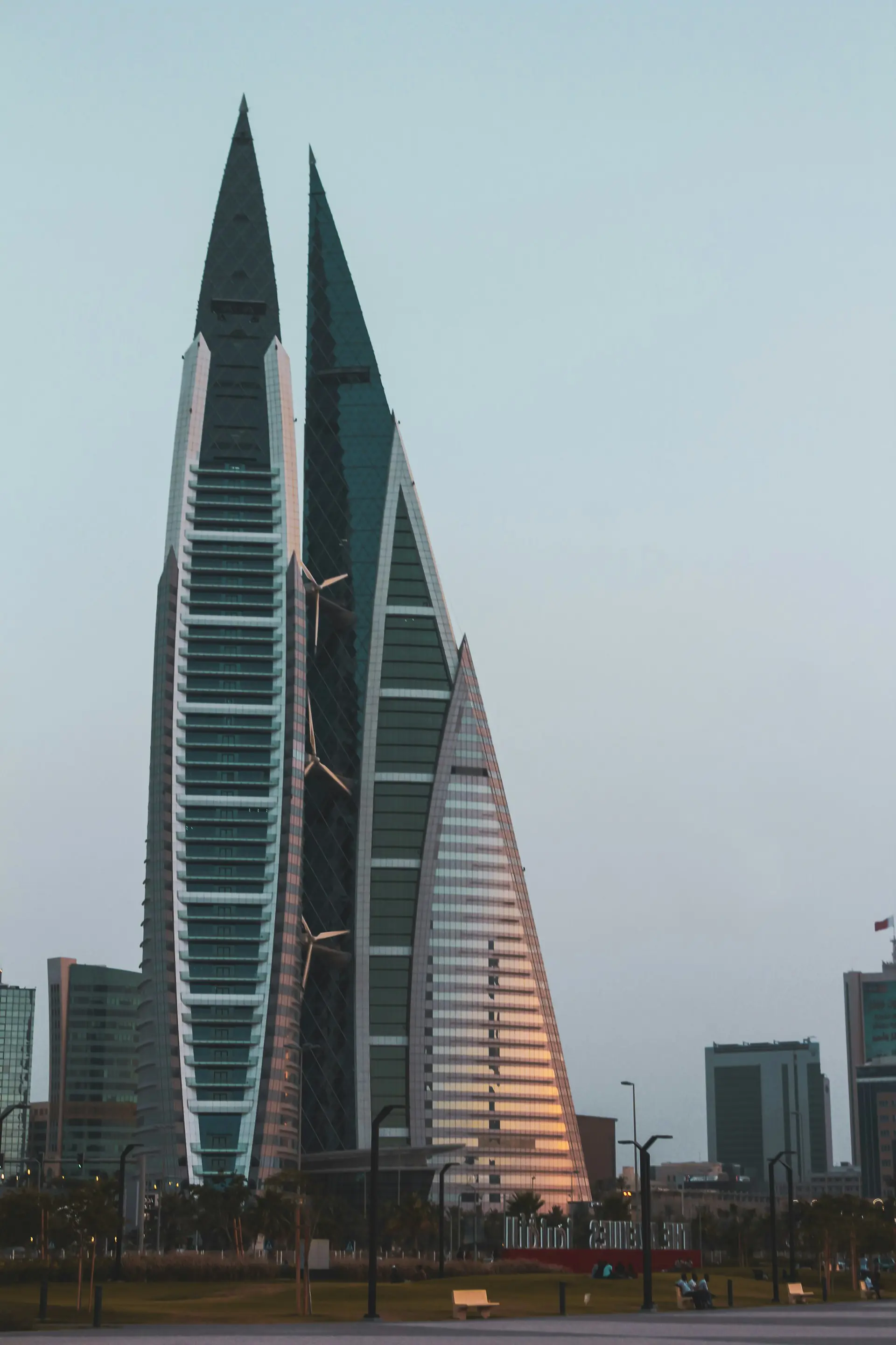 Två moderna höghus med glasfasader i centrala Manama, Bahrain, i gryningen