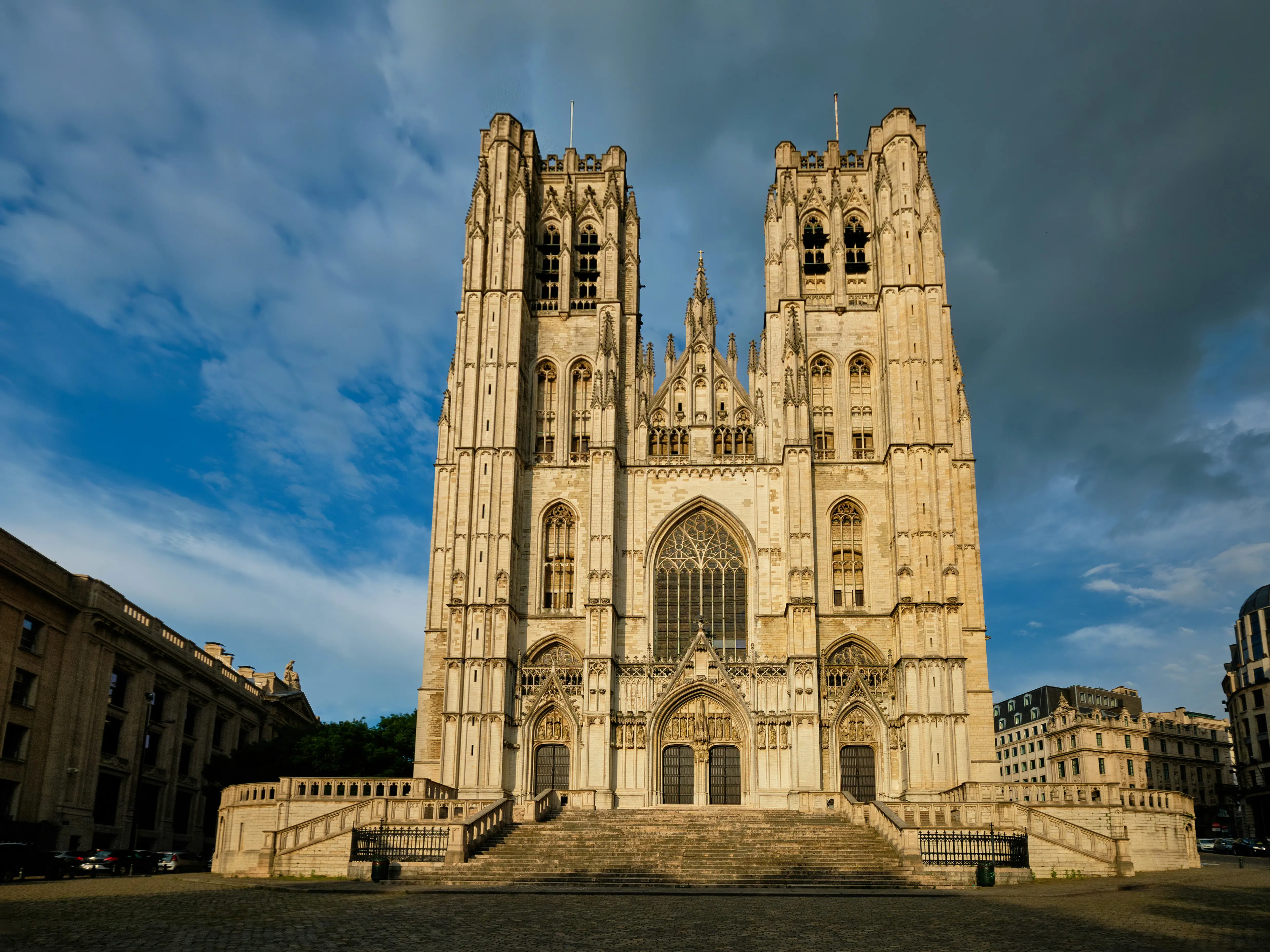 Gothic-style cathedral in Brussels with twin towers against a dramatic sky.
