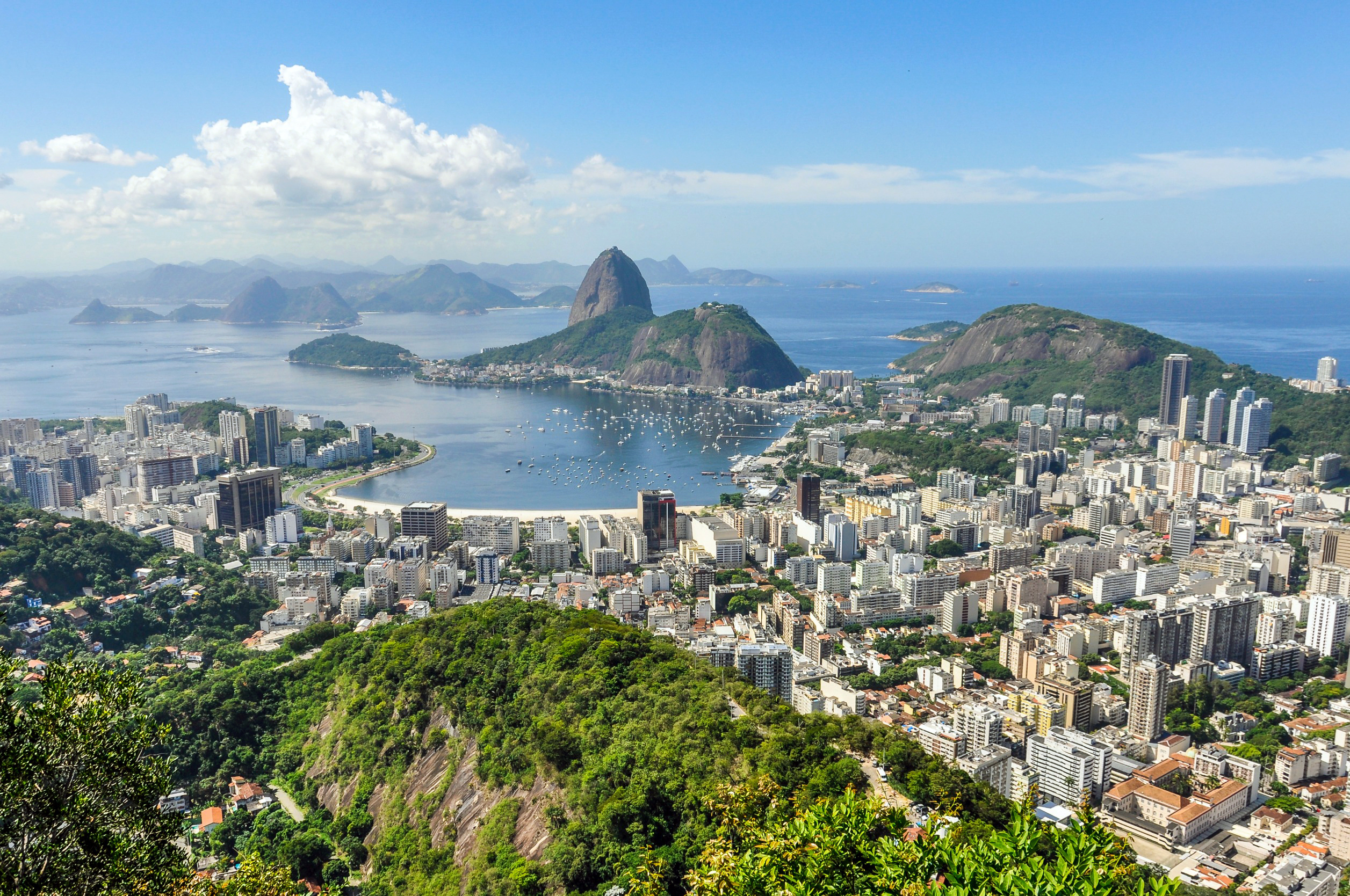Resa till Rio de Janeiro - Panoramautsikt över Rio de Janeiro med Sugarloaf Mountain och Guanabara Bay, omgiven av stadsbebyggelse.