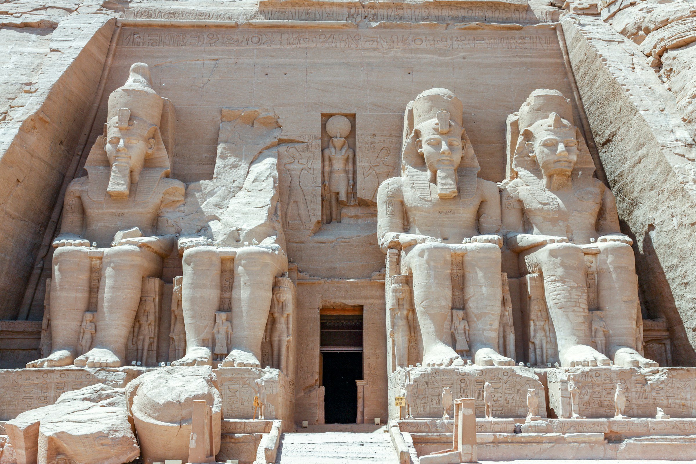 Great Temple of Abu Simbel in Egypt, featuring four colossal statues of Ramses II seated at the entrance, carved into the limestone rock face.