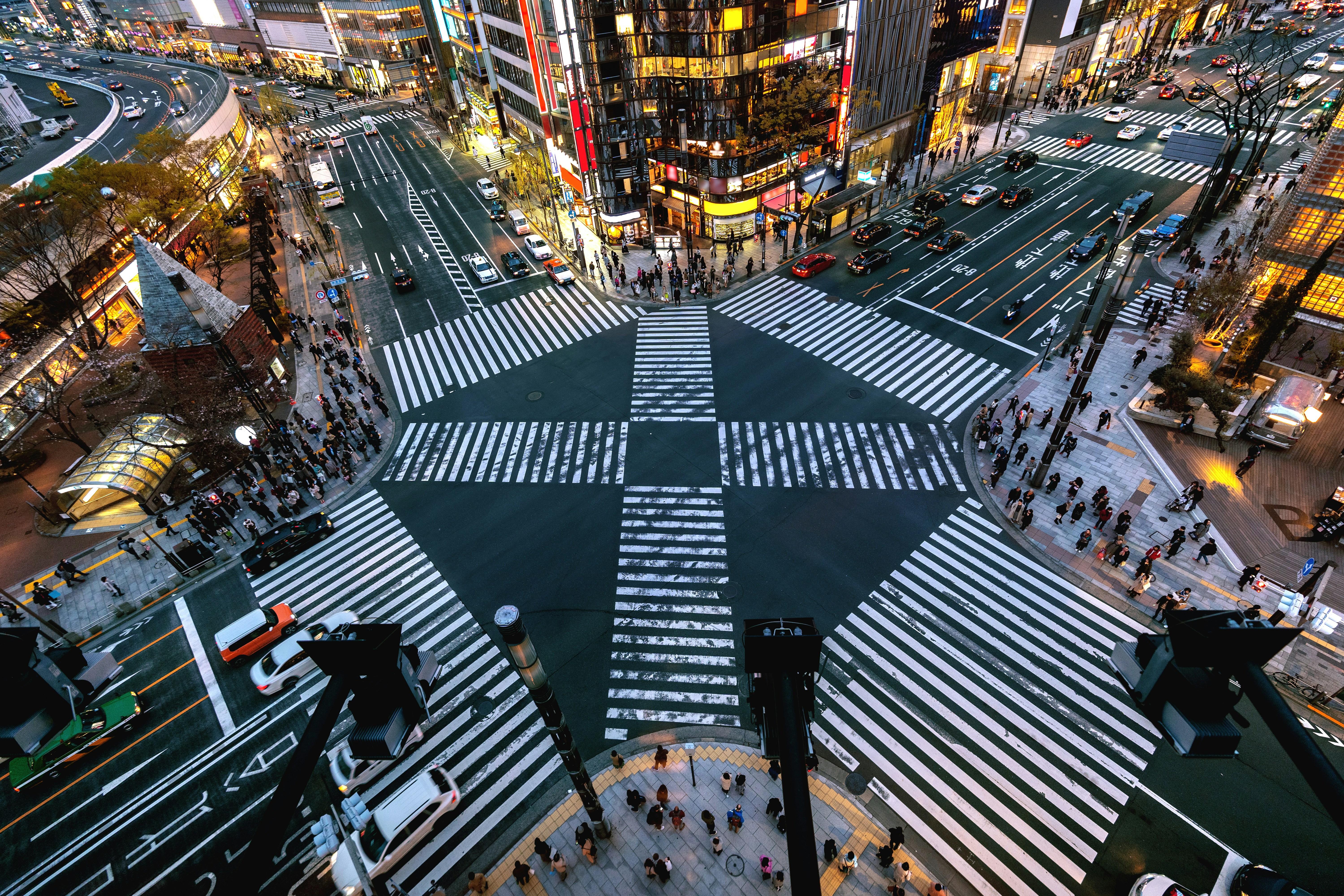 View from above on the famous Shibuya intersection in central Tokyo with traffic, people and lighting all around