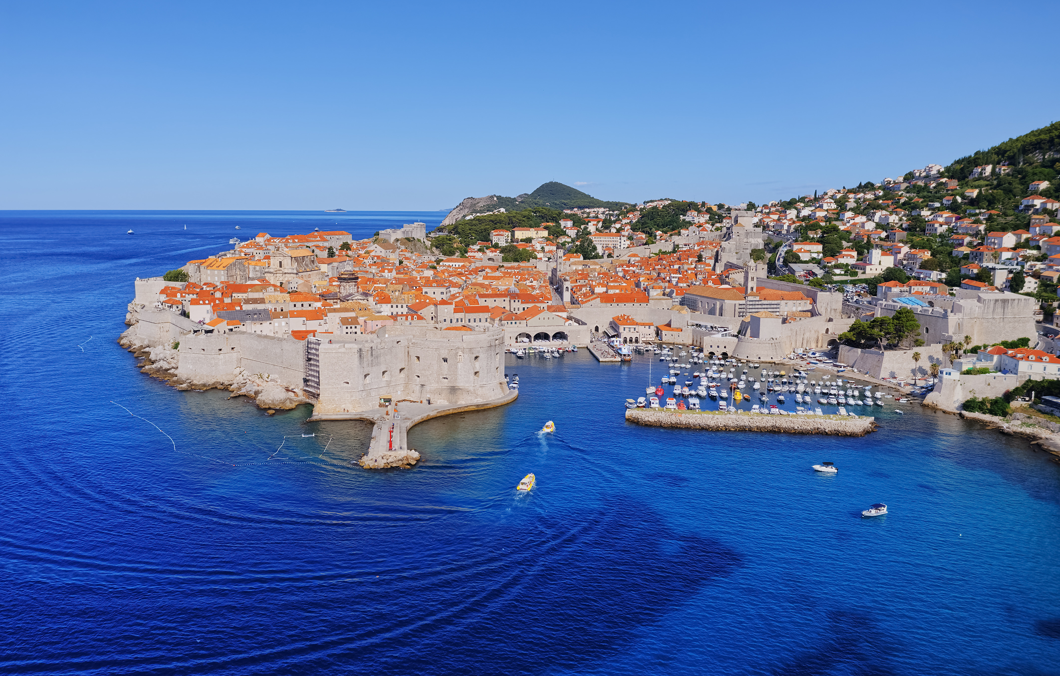 Aerial view of Dubrovnik, Croatia, showcasing the historic city walls, iconic terracotta rooftops, and the deep blue Adriatic Sea