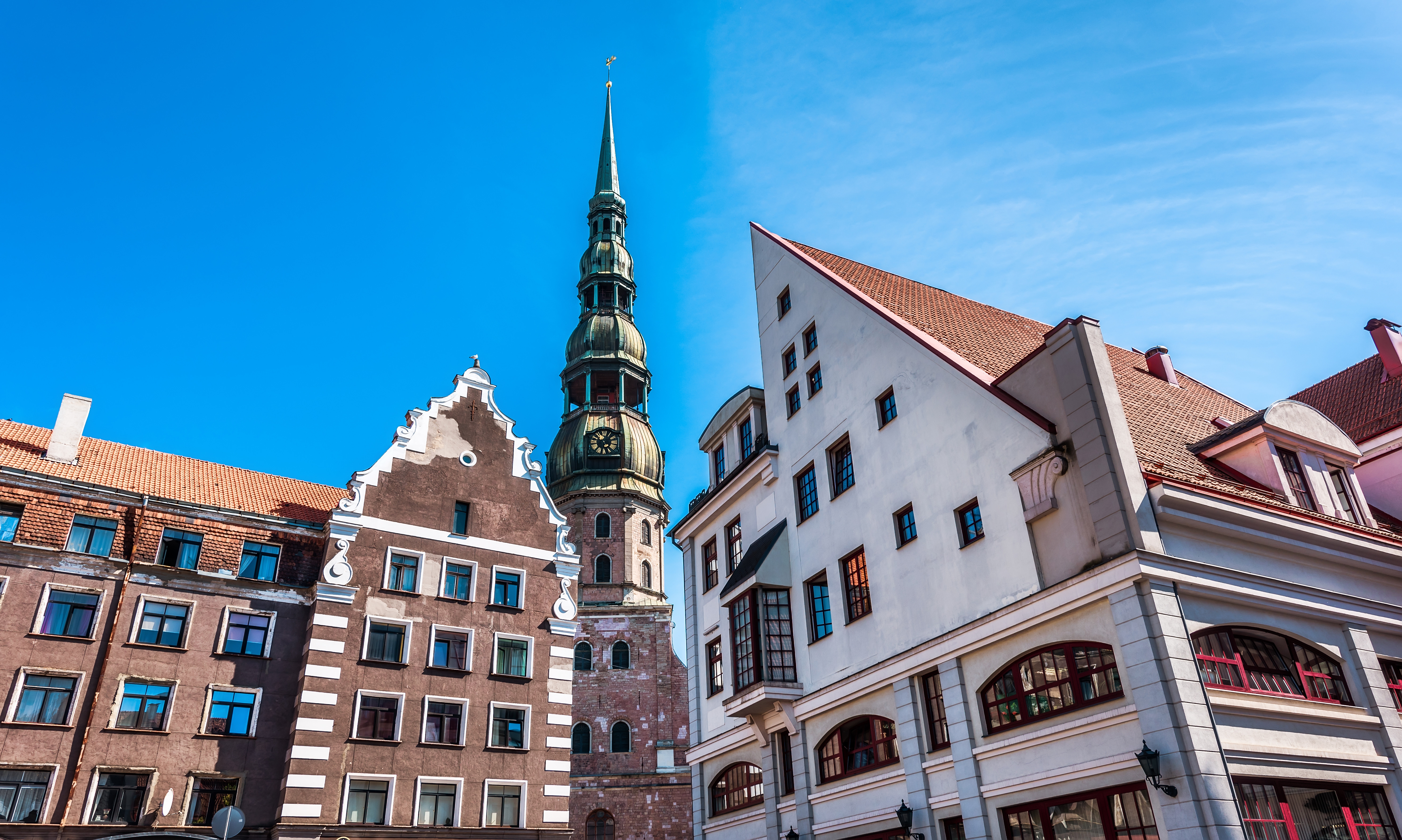 Historic architecture and church spire in Riga, Latvia, under a clear blue sky