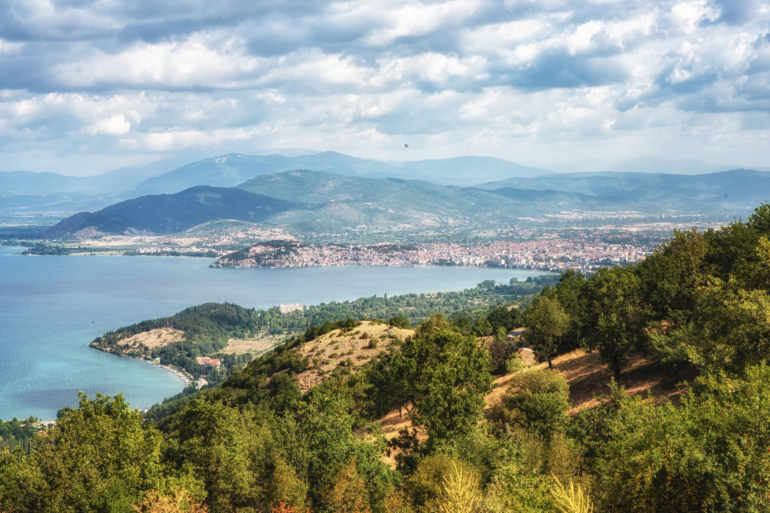 Panoramavy över en skogssluttning ner mot ett blått hav med öar i Nordmakedonien