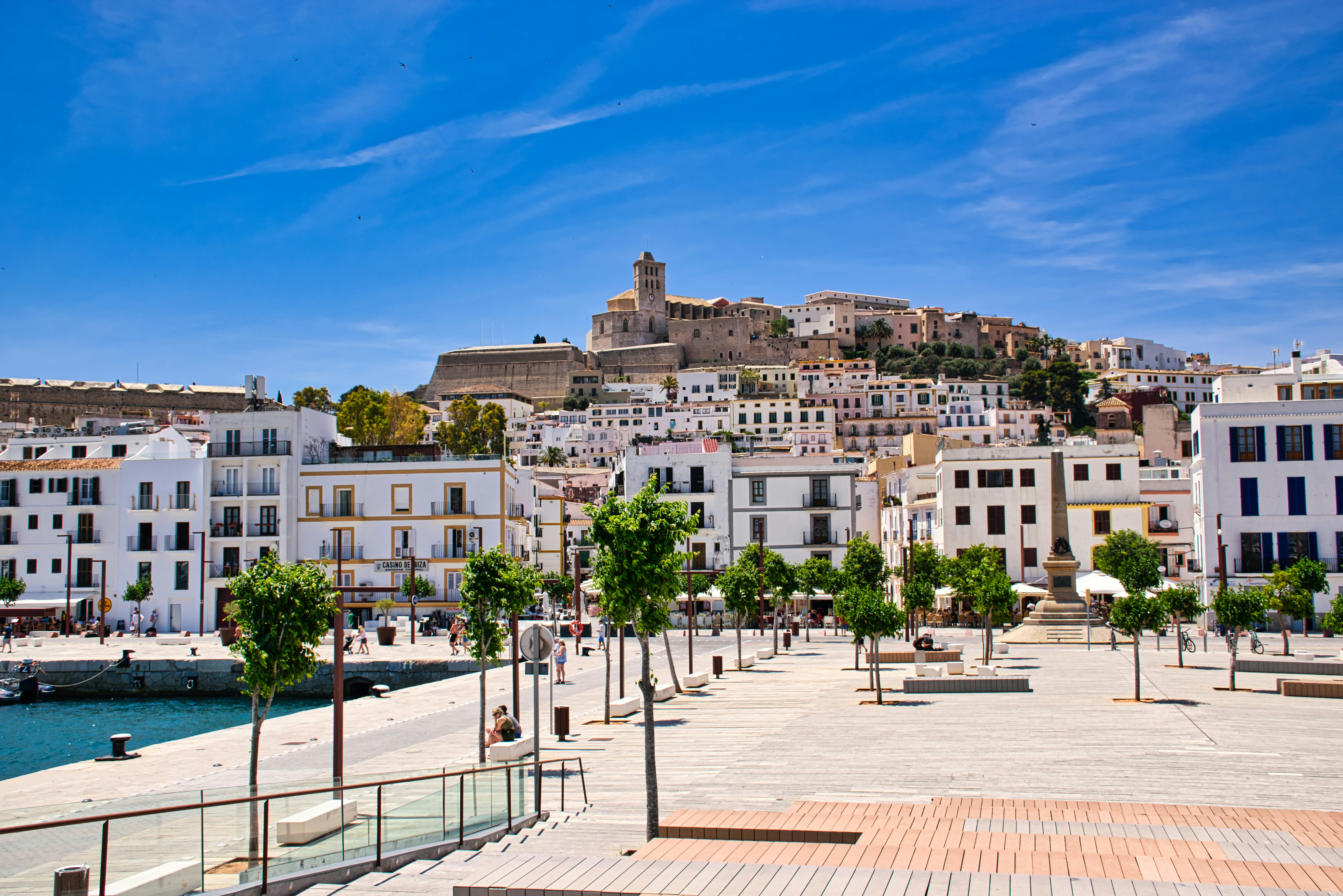 Historic Ibiza town with white buildings and a castle on a sunny day, set against a clear blue sky