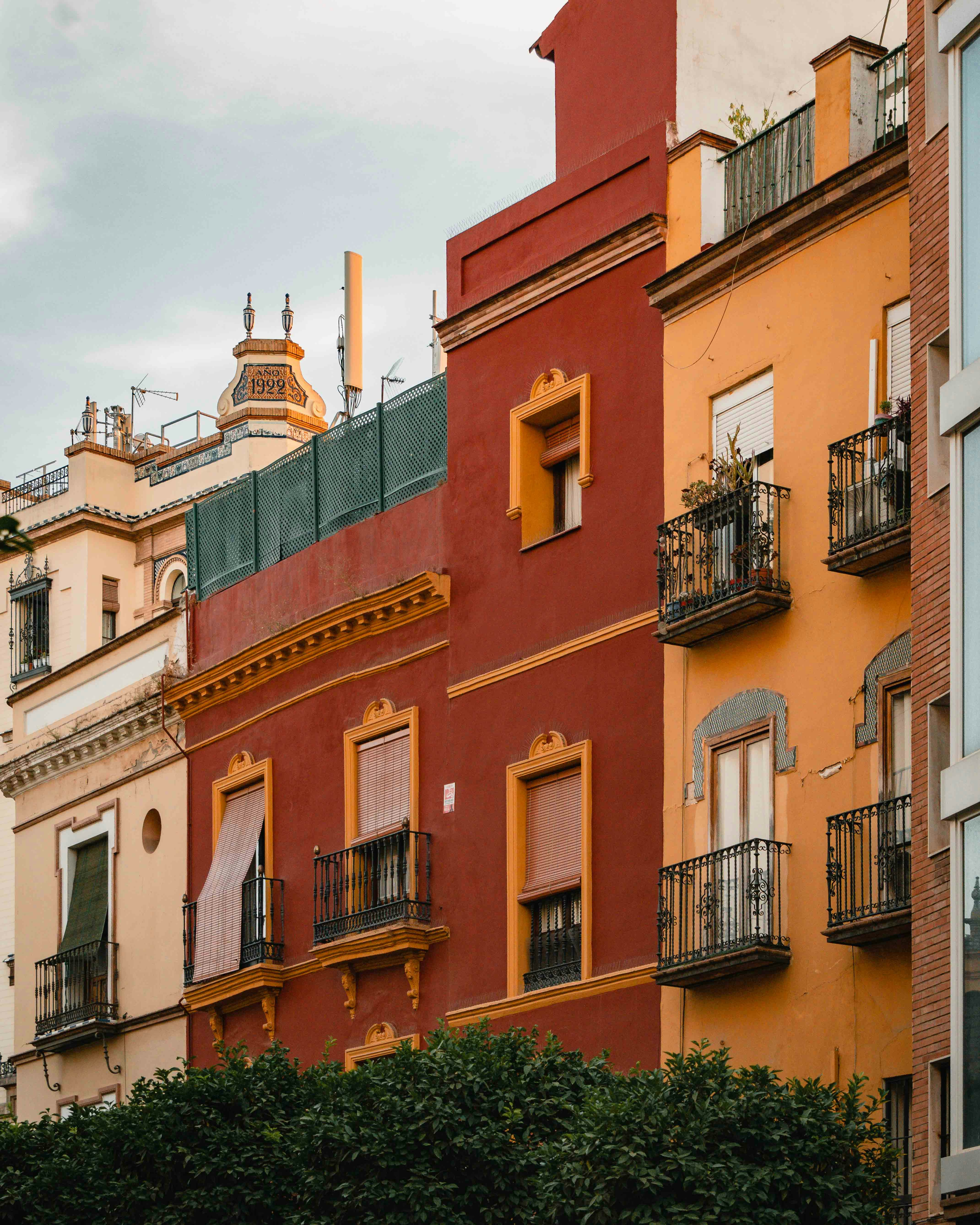 Colorful European apartment buildings with red and orange facades and decorative balconies