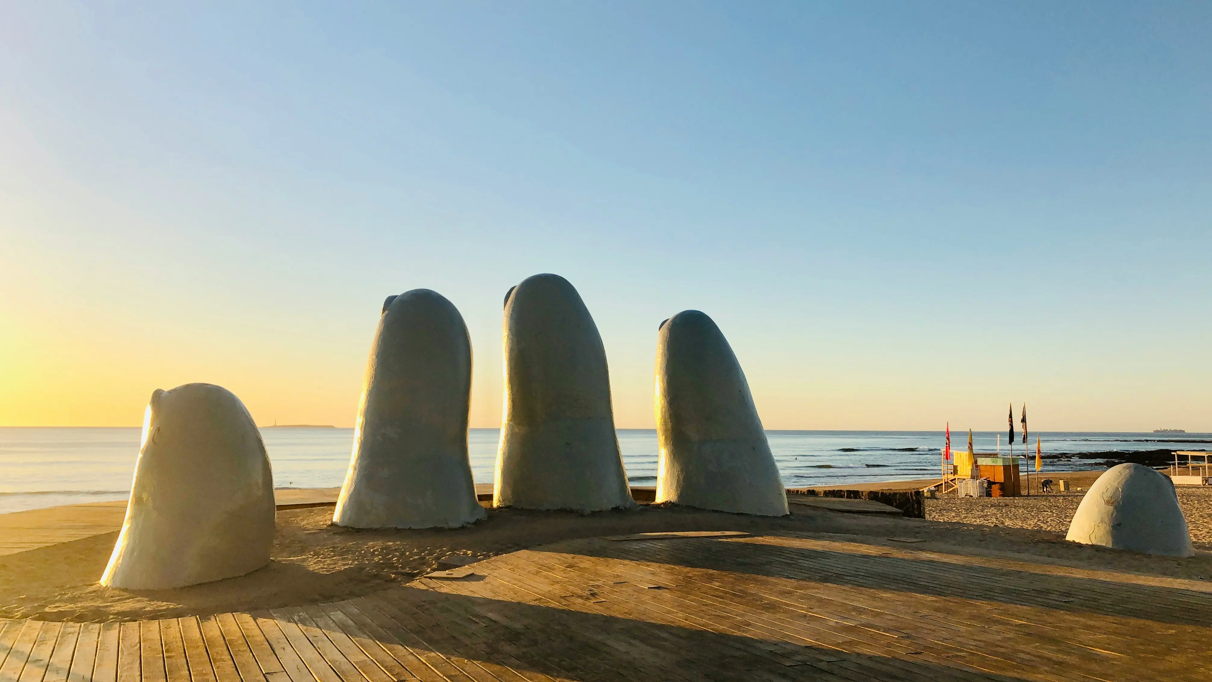 Giant hand sculpture on sandy beach at sunrise, Punta del Este, Uruguay