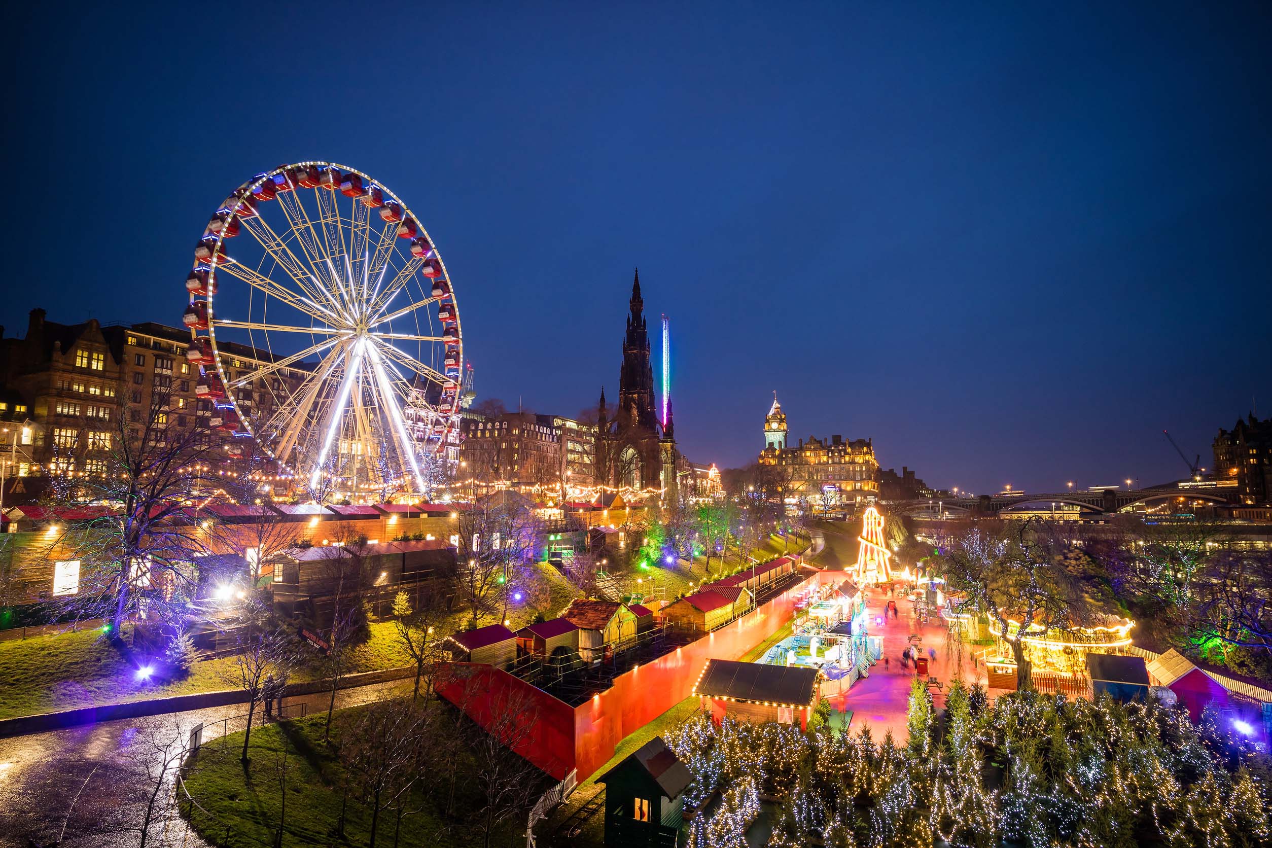 Julmarknad i Edinburgh med upplyst pariserhjul, slottet och färgglada ljus i Princes Street Gardens – vinterresa till Skottland